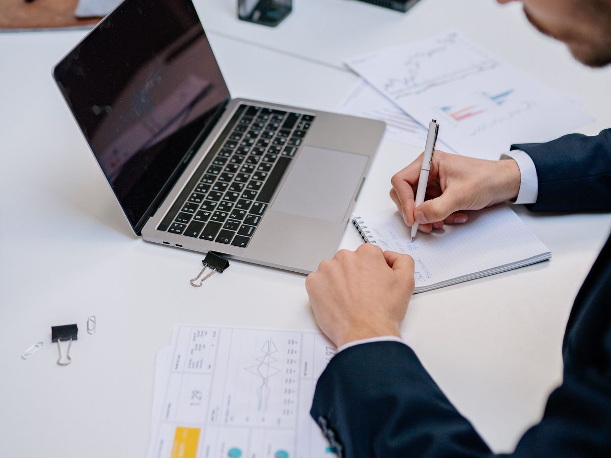 Business owner reviewing plans and figures beside a laptop