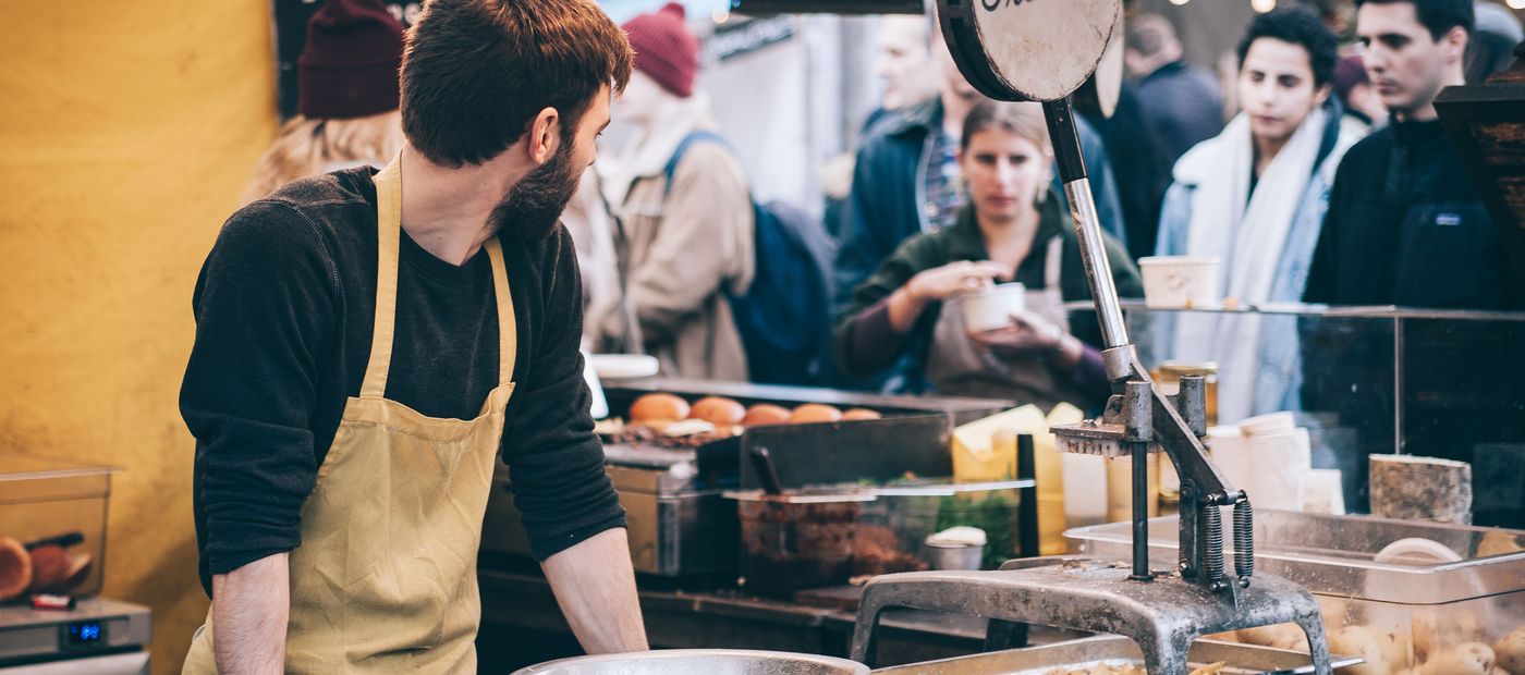 A small business owner working behind the counter of a market stall